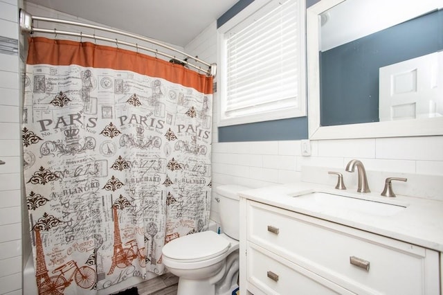 full bath featuring curtained shower, tile walls, toilet, and vanity