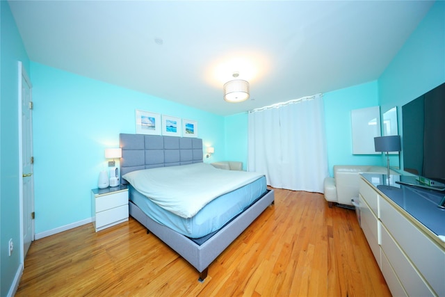 bedroom with light wood finished floors and baseboards