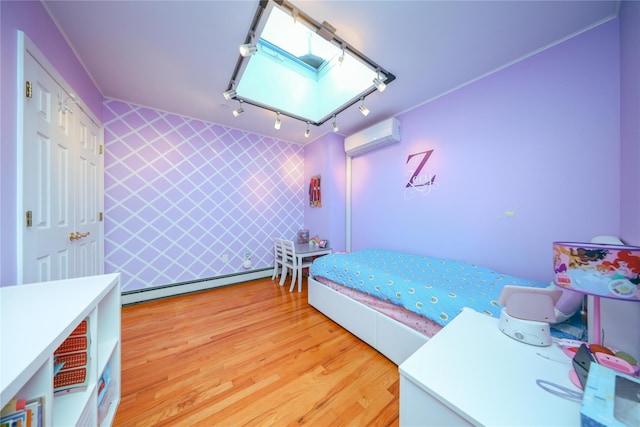 bedroom featuring an accent wall, a wall unit AC, a skylight, light wood-style floors, and a baseboard radiator