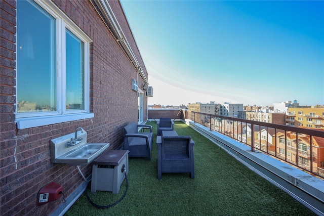 view of patio / terrace featuring a city view, a balcony, and a sink