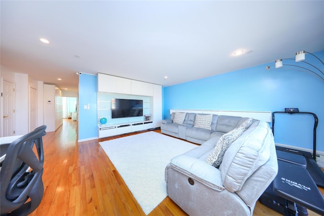 living area with recessed lighting, light wood-type flooring, and baseboards