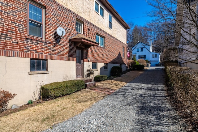 exterior space featuring brick siding and driveway