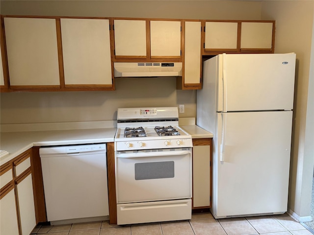 kitchen featuring under cabinet range hood, light tile patterned floors, white appliances, and light countertops