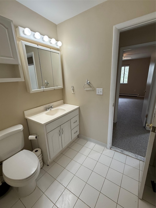 half bath with vanity, baseboards, tile patterned flooring, a baseboard heating unit, and toilet