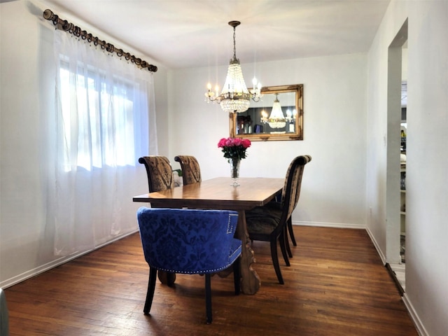 dining space with a chandelier, wood-type flooring, and baseboards