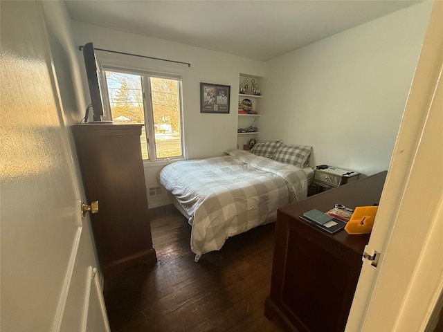 bedroom featuring visible vents and dark wood finished floors