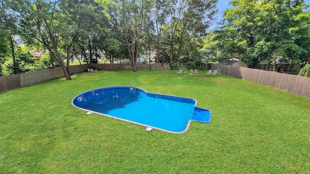 view of swimming pool featuring a lawn, a fenced backyard, and a fenced in pool