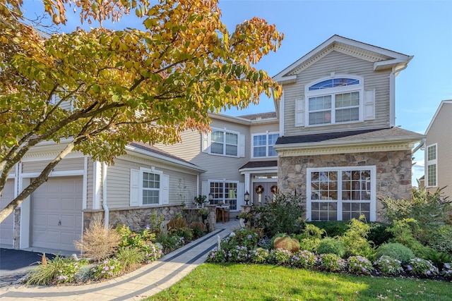 traditional-style home featuring an attached garage and stone siding