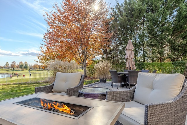 view of patio with an outdoor living space with a fire pit, fence, and outdoor dining space