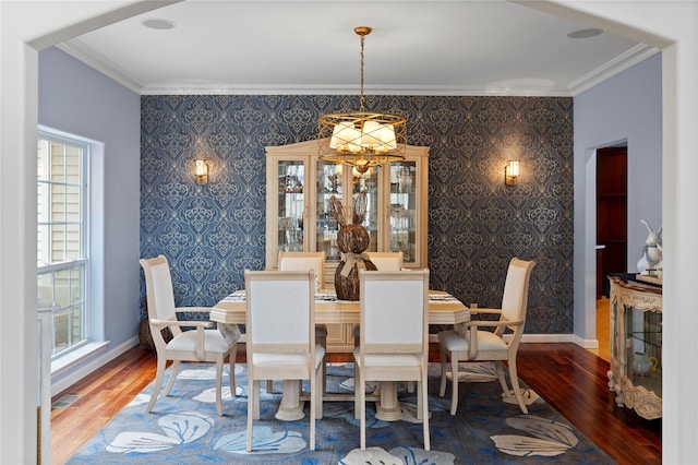 dining space featuring wallpapered walls, baseboards, ornamental molding, and wood finished floors