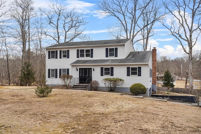 view of front of home with a front lawn and a chimney