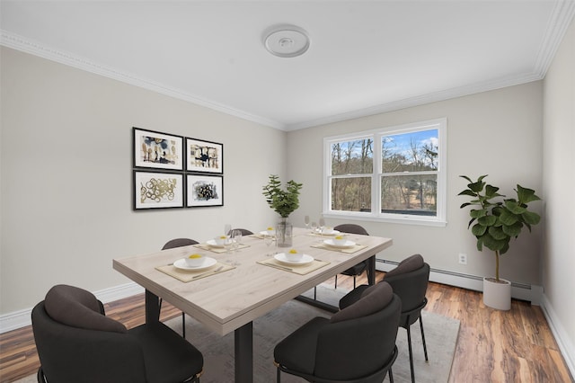 dining room with ornamental molding, a baseboard radiator, baseboards, and wood finished floors