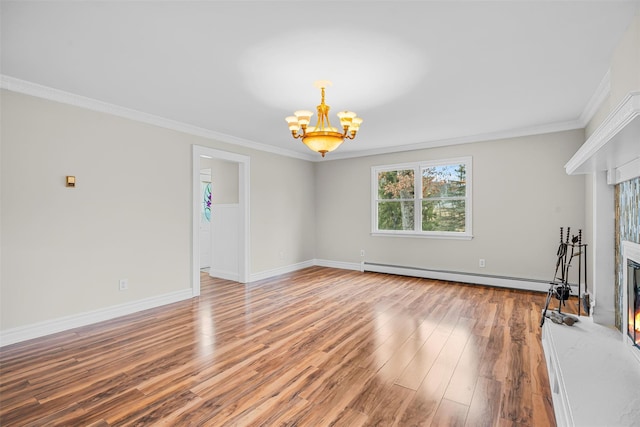 unfurnished living room featuring light wood finished floors, a lit fireplace, ornamental molding, baseboard heating, and a notable chandelier