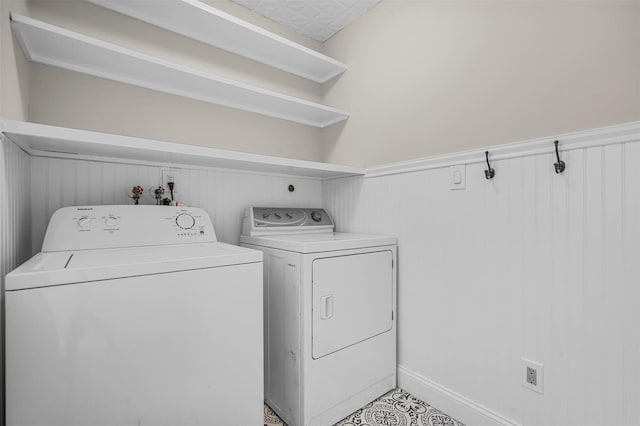 laundry area with a wainscoted wall, laundry area, and washing machine and clothes dryer