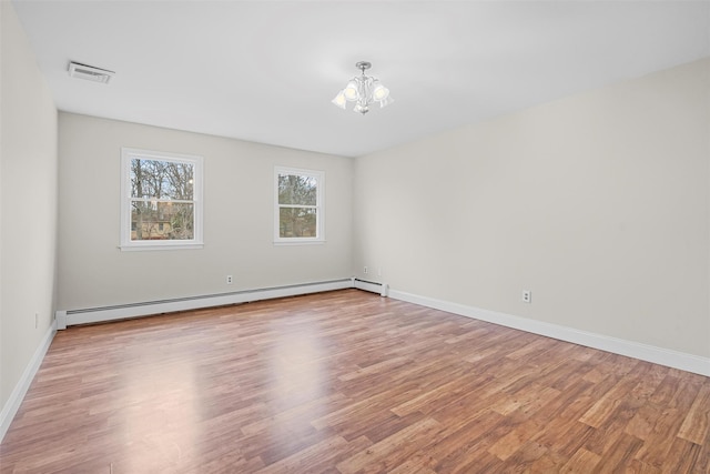 empty room with a baseboard heating unit, visible vents, and light wood-type flooring