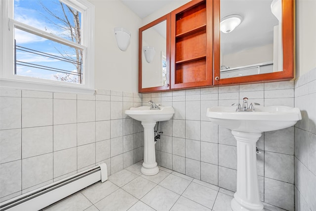 bathroom with baseboard heating, tile walls, wainscoting, and tile patterned flooring