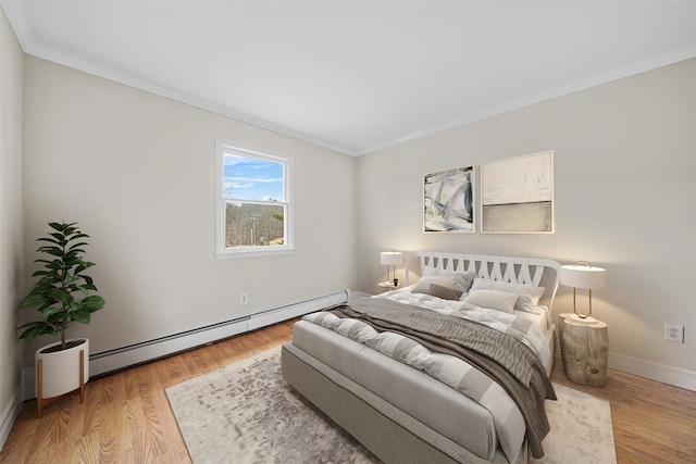 bedroom with a baseboard heating unit, baseboards, wood finished floors, and crown molding