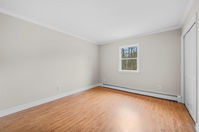 unfurnished bedroom with a closet, crown molding, light wood finished floors, baseboards, and baseboard heating