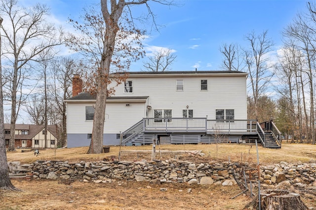 back of property featuring a deck, stairs, and a chimney