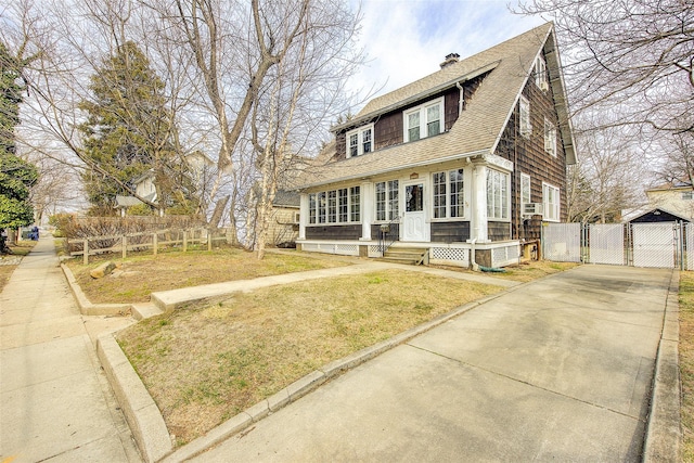 view of front of property with a gate, fence, a chimney, a shingled roof, and concrete driveway