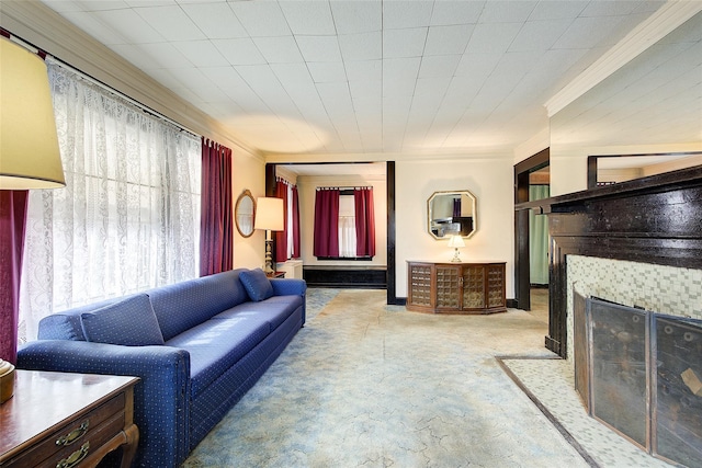 living room featuring baseboards, carpet floors, crown molding, and a tile fireplace