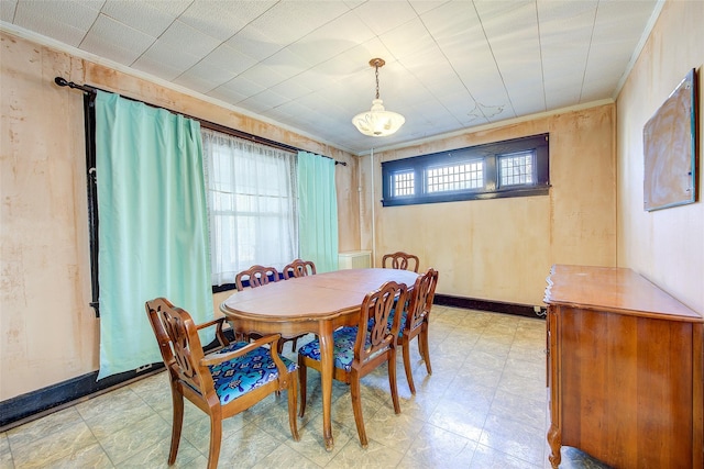 dining room with light floors, crown molding, and baseboards