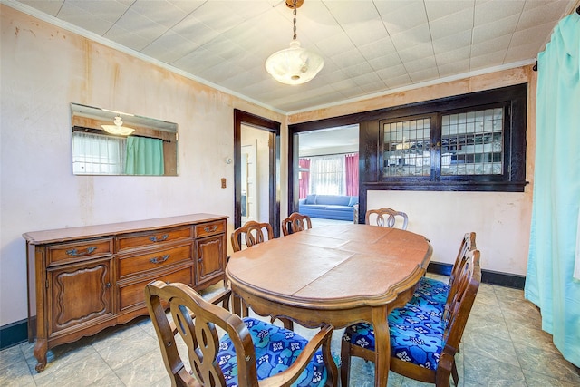 dining space with baseboards and crown molding