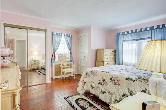 bedroom with baseboards, a closet, wood-type flooring, and ornamental molding