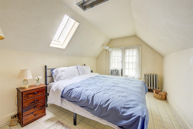 bedroom featuring baseboards, lofted ceiling with skylight, and radiator heating unit