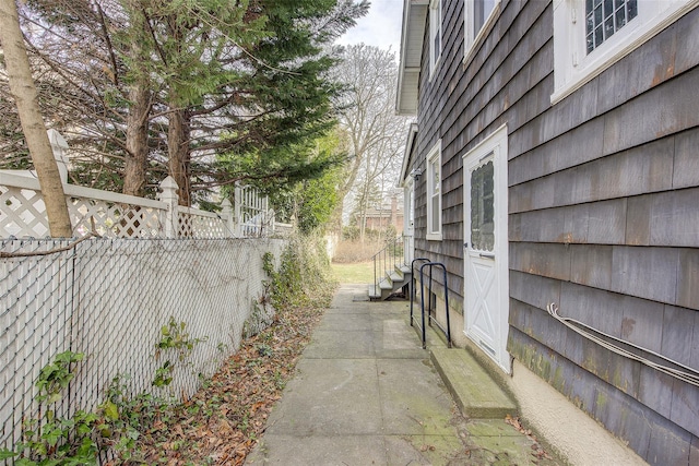 view of side of home with entry steps and fence