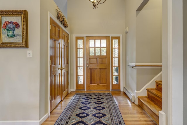 entrance foyer with a wealth of natural light, light wood-type flooring, and a baseboard radiator