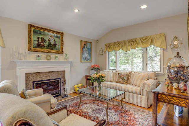 living area featuring a glass covered fireplace, wood finished floors, lofted ceiling, and recessed lighting