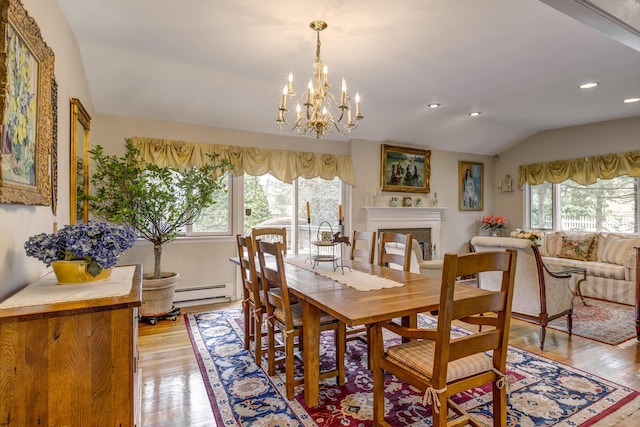 dining area featuring a fireplace, recessed lighting, a baseboard heating unit, vaulted ceiling, and light wood-type flooring