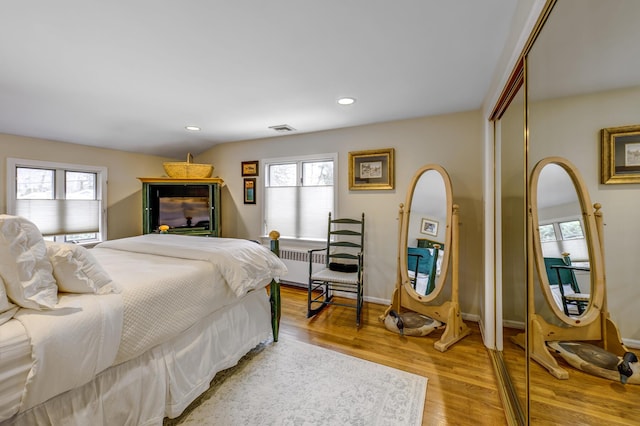 bedroom with light wood-style flooring, multiple windows, visible vents, and recessed lighting