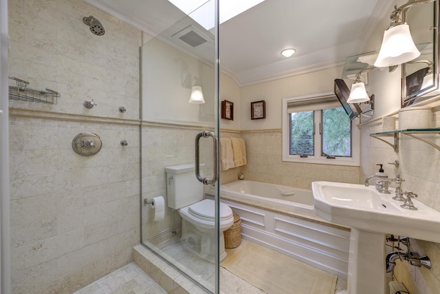 bathroom with toilet, ornamental molding, a tile shower, and tile walls