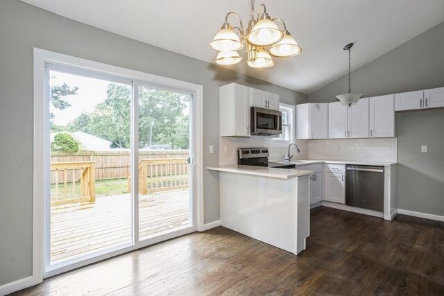 8 Fleet Rd, Shirley, NY 11967 - kitchen featuring dark wood-style flooring, stainless steel appliances, light countertops, a sink, and a peninsula