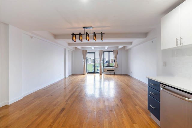 unfurnished living room featuring baseboards, beamed ceiling, and light wood-style floors