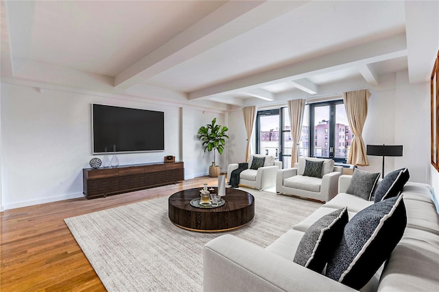 living room featuring beamed ceiling, baseboards, and wood finished floors