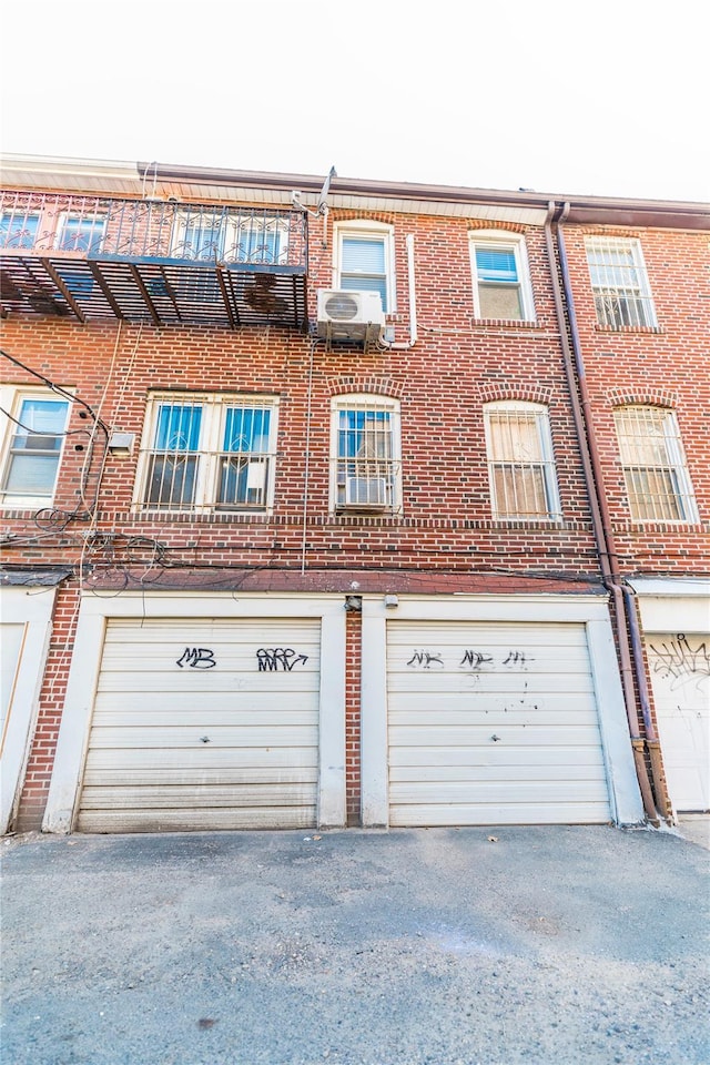 exterior space featuring driveway, brick siding, and an attached garage