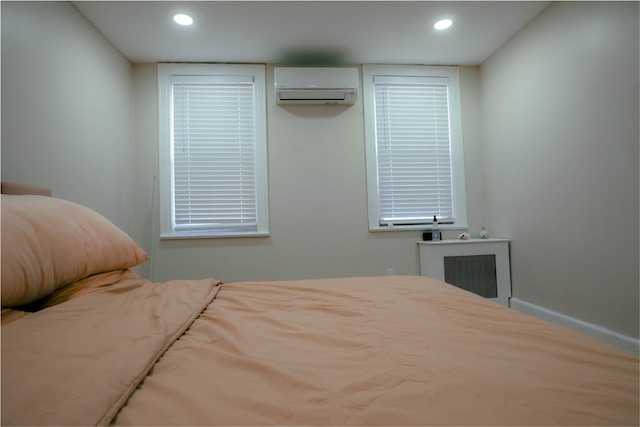 bedroom featuring radiator, recessed lighting, and a wall mounted AC