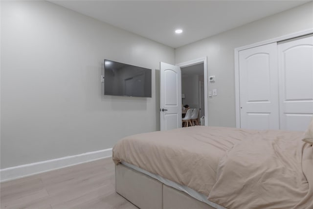 bedroom featuring light wood finished floors, baseboards, a closet, and recessed lighting