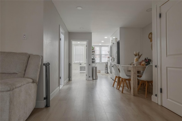 hall with recessed lighting, light wood-style flooring, and baseboards