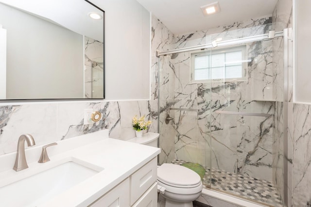 full bathroom featuring toilet, vanity, and a marble finish shower