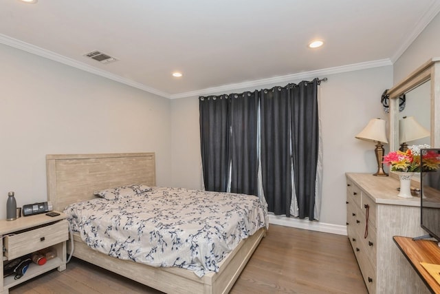 bedroom with ornamental molding, recessed lighting, visible vents, and wood finished floors