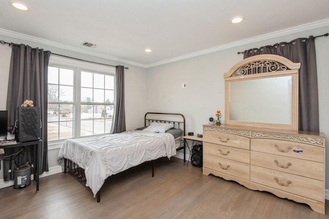 bedroom with ornamental molding, recessed lighting, visible vents, and wood finished floors