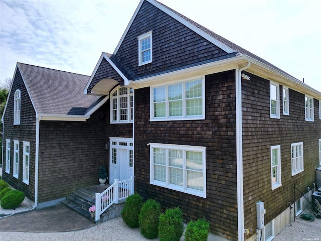 shingle-style home featuring roof with shingles