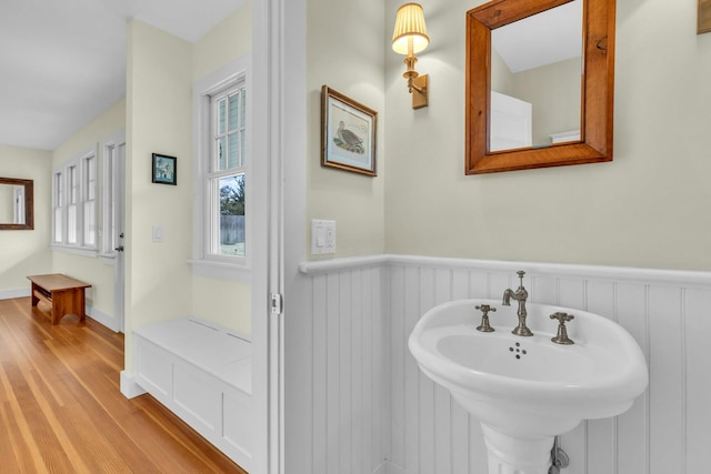 bathroom featuring wood finished floors and a wainscoted wall