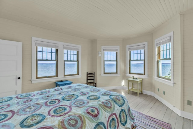 bedroom with wooden ceiling, baseboards, and wood-type flooring