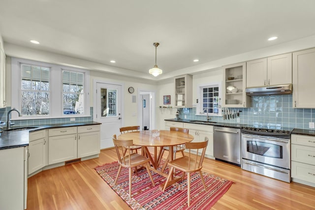 140 Newtown Rd, Hampton Bays, NY 11946 - kitchen with under cabinet range hood, stainless steel appliances, dark countertops, and a sink