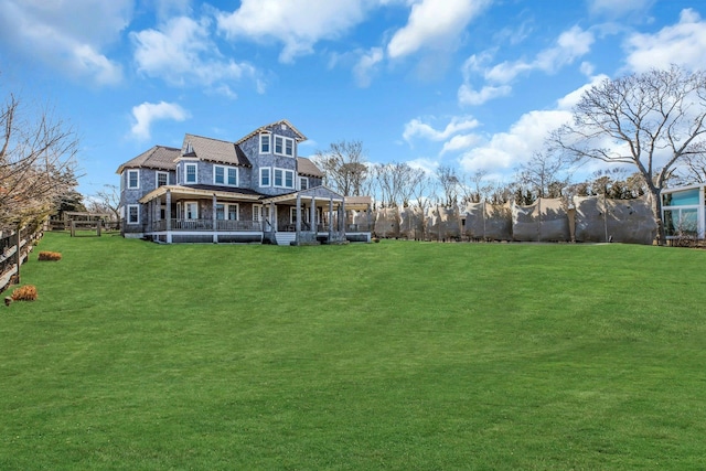 140 Newtown Rd, Hampton Bays, NY 11946 - rear view of property featuring a yard, fence, covered porch, and stone siding